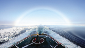 在船尾不仅可看到破开的“冰路”，停着的直升飞机，还可看到美丽的虹。