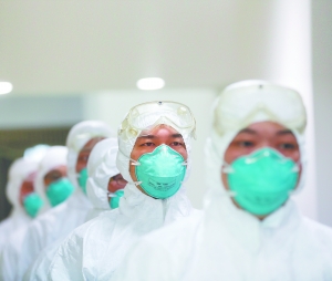 　　昨日，武汉市举行首场人感染禽流感应急演练。医务人员身穿专业防护服进入隔离区将采集到的“患者”唾液样本进行专业封装运往化验室。IC 图
