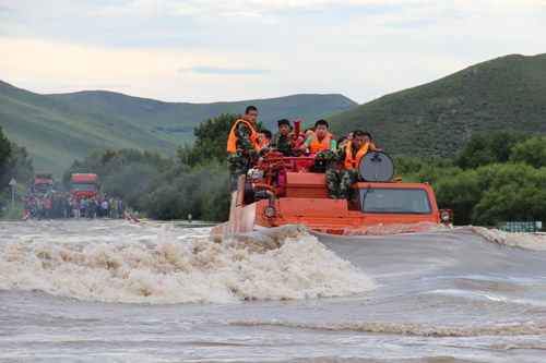 公安民警和消防官兵驾驶装甲车运载游客通过没水路面