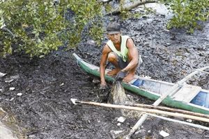 　　8月19日，科尔多瓦镇居民正在清理红树附近的黑色油污。路透