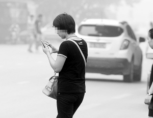 　　■过马路还在低头看手机，太危险了!本报记者 郄磊 摄