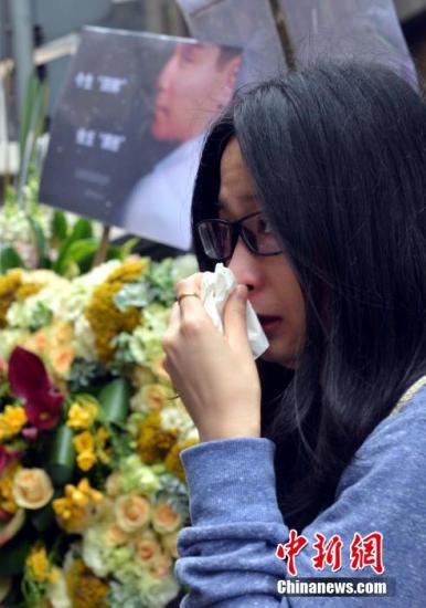 一名女“粉丝”向“哥哥”摆放鲜花后悼念留泪。