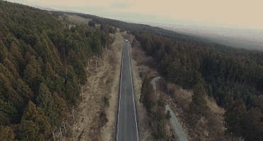 两辆载满女学生的大巴行驶在山间马路上↓