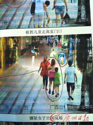 监控录像中显示,阿玲(箭头所指者)带着大儿子看到“二傻”正在垃圾桶内捡食。