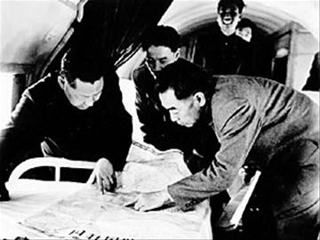 1958年4月，周恩来总理与习仲勋（左）在飞机上研究三门峡水库建设资料。
