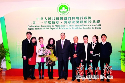卢伟硕（右四）在接受澳门特别行政区“仁爱勋章”之后，澳门特区政府行政长官崔世安（右五）与之合影。  资料图片