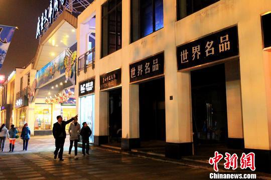散步路过常熟市民在指点已关门的“世界名品店”。 李克祥 摄