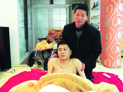 瘫痪雇主万力只能在护工的帮助下才能坐。记者史强 摄