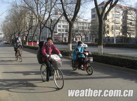 河北天气晴冷,骑车的人还是裹得严严实实的