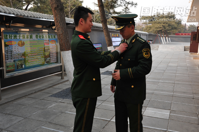 刘帅班长帮蔡东桦整理衣服。