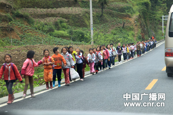 在贵州的乡村公路上随处可见步行上学的孩子