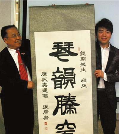 张鹏向郎朗(右)赠送墨宝.