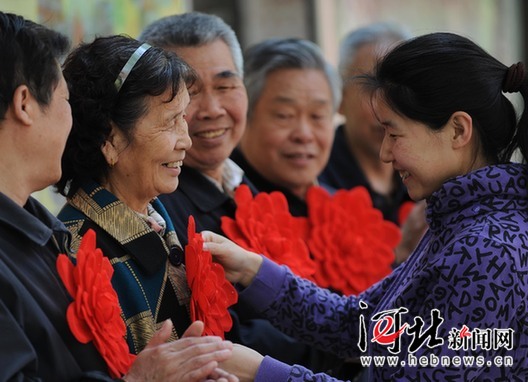 4月26日,几名劳模高兴地戴上了大红花.