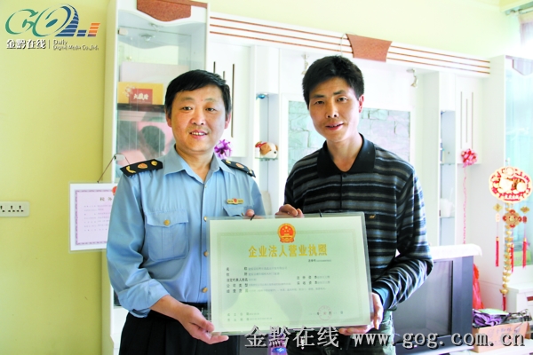 瓮安县工商局干部帮助周明刚办理微型企业营业执照。　　