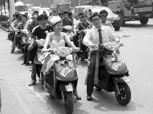 新郎新娘骑电动车行驶在路上