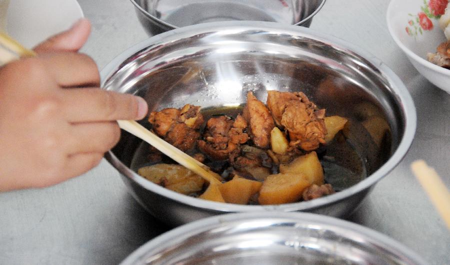 7月3日，黑龙江省绥化市青冈县连丰乡中心小学的一名学生在吃土豆炖鸡肉。新华社记者 王凯 摄