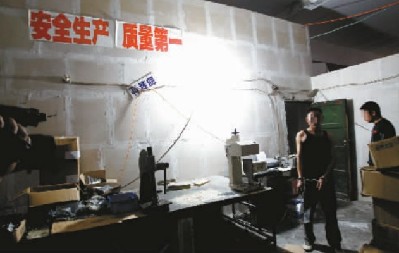 ■在制假窝点墙上贴着“安全生产质量第一”标语 记者 杨帆摄
