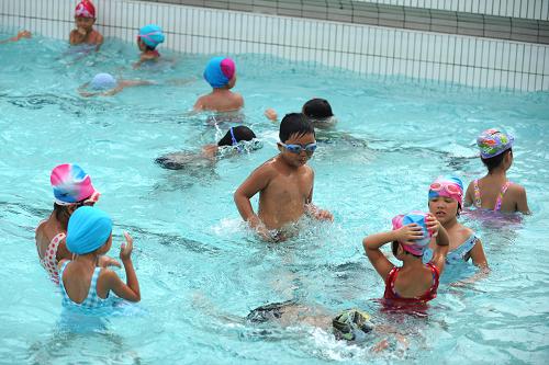 7月11日,孩子们在游泳池里玩水.