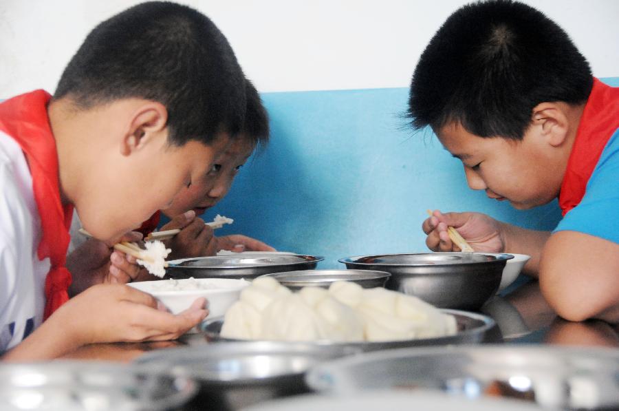 7月3日，黑龙江省绥化市青冈县连丰乡中心小学的学生在食堂吃营养午餐。新华社记者 王凯 摄
