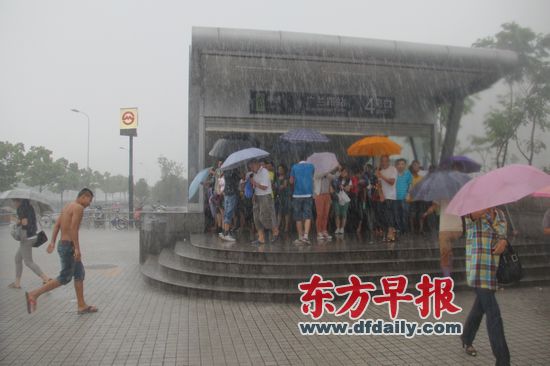 因受强台风“海葵”影响,地铁2号线东延伸段从昨日12时30分起停止运营。图为广南路站4号出口,乘客在等待接送车。 早报记者 孙湛 实习生 刘淑宏 图