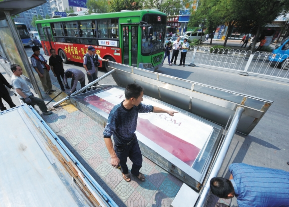 公交候车亭“栽倒”在机动车道上。