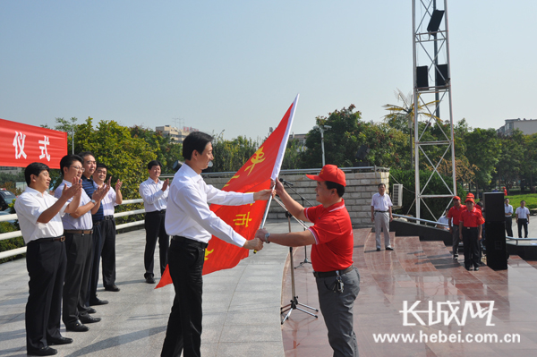 高碑店市长韩晓明为志愿者授旗。李光宇 摄
