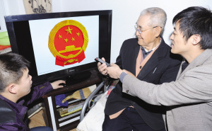 海信电器送来40英寸液晶让老人用电视看国徽