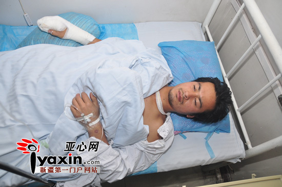 图为,30日19时许,在解放军23医院住院部,马有卜的右手缠着绷带在床上