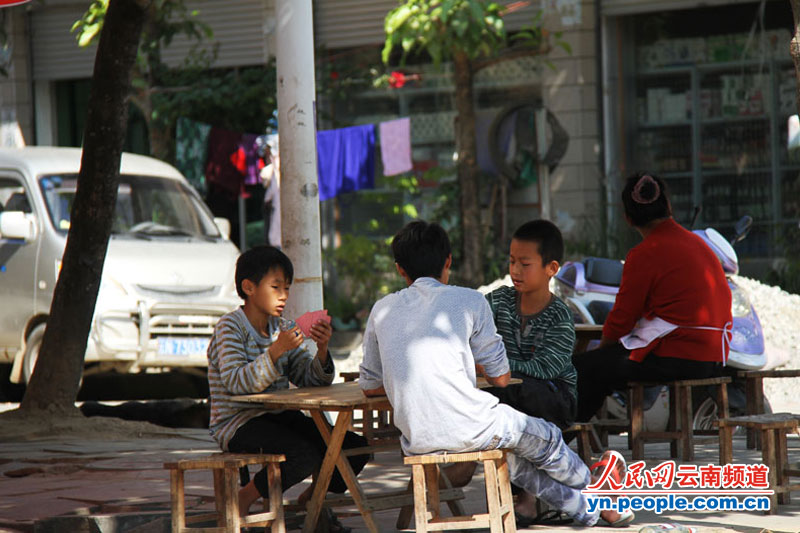 那邦镇街道旁边的几个孩子在打扑克.摄影:赵文瑞