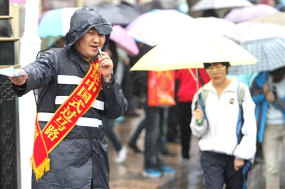 "黑龙江晨报"字样的绶带,成为劝阻行人闯红灯的志愿者,与交警一起站岗