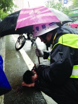 骑车人倒地昏迷,路人交警轮番撑伞