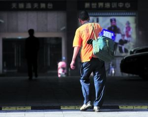 　　上海，一名快递员背着快件准备进入写字楼。王炬亮 早报资料