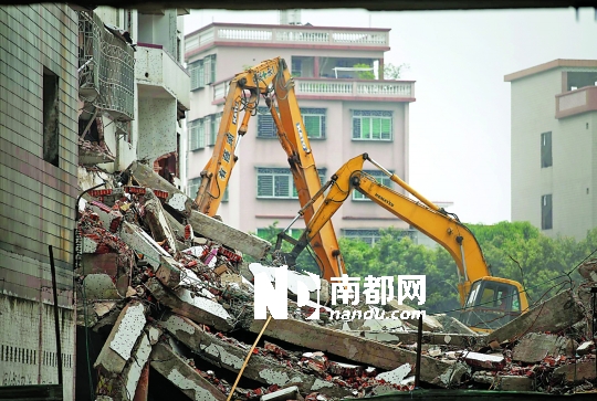 5月23日早上,拆迁户被强制带离后,两台挖机在她家楼下继续拆房子.