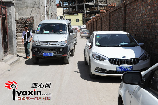 图为8月6日，开发商建设的围墙只给村民们留下了窄窄的道路，如果路上有两车通行，行人就基本无路可走。亚心网记者 张万德 摄