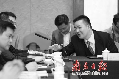 政协委员温纯青在分组讨论上与其他委员交流提案.