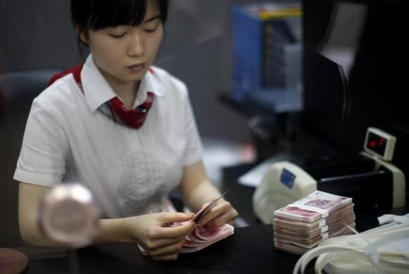 图为上海自贸区一家工行的职员在清点钞票.图片来源:路透