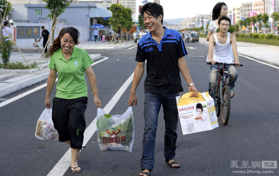 2010年8月1日,东莞长安镇,工业区并肩走着的男女工人.