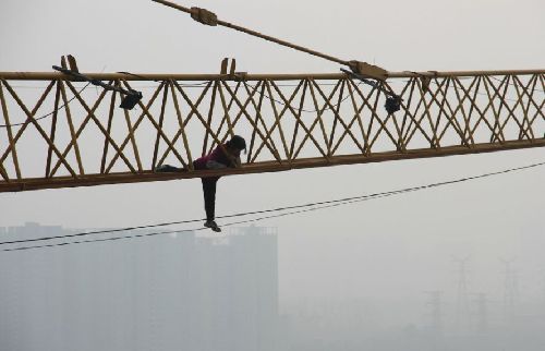 四川:女子讨薪不成 爬上50米高塔吊欲跳楼(组图)