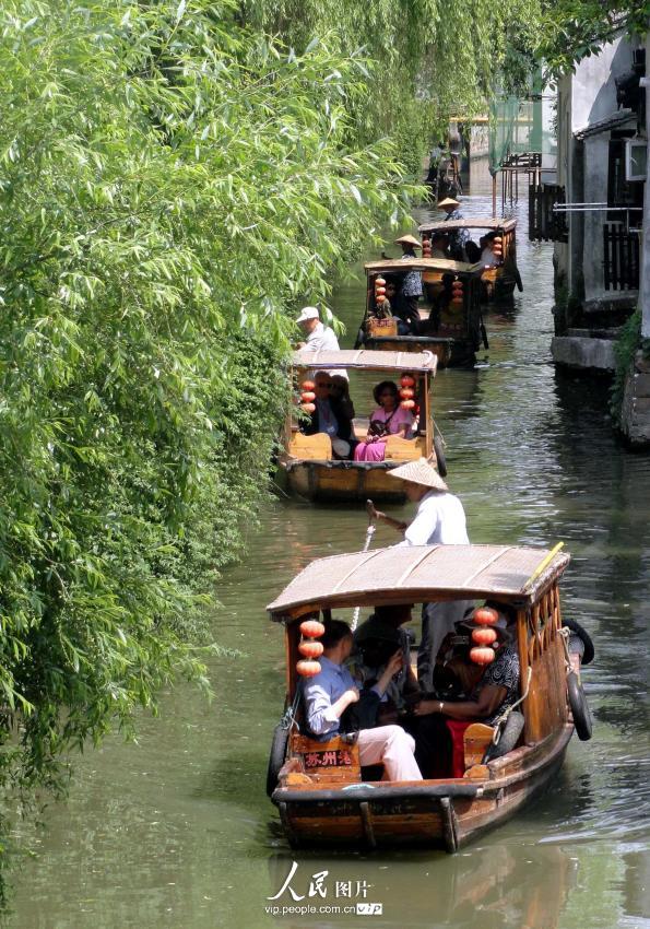 5月28日,载着游客的仿古游船在苏州山塘河驶行