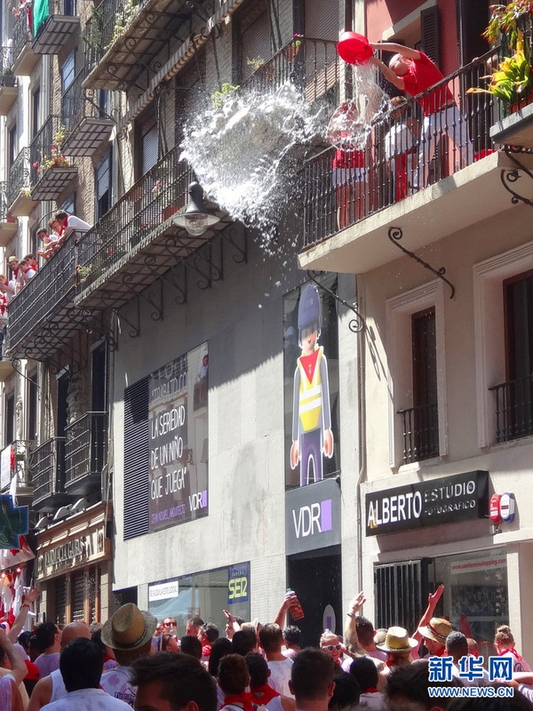 一位居民从阳台上向人群泼水.新华社记者 周喆摄