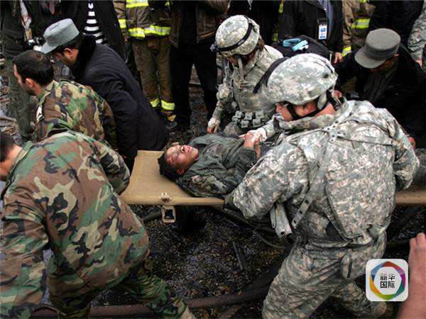 图为2009年阿富汗首都喀布尔一次汽车炸弹爆炸现场,一名受伤的美军