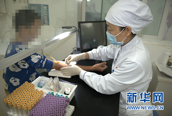 许洪新为患者抽血.(图片由302医院提供)