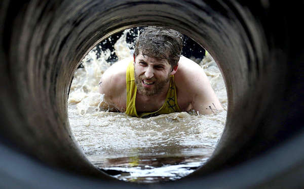 英国"强悍泥人"赛堪比魔鬼训练 选手要穿过挂满通电电线的水塘