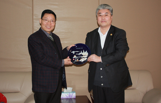 报告会前,党委书记于志刚(右)与报告团成员座谈,并向他们赠送纪念品.