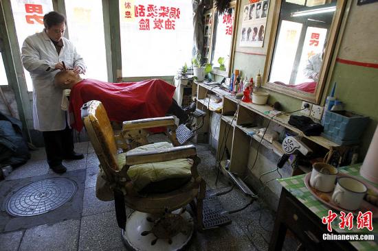 在北京菜市口米市胡同,一家有近百年历史的云风理发店,吸引了大批老