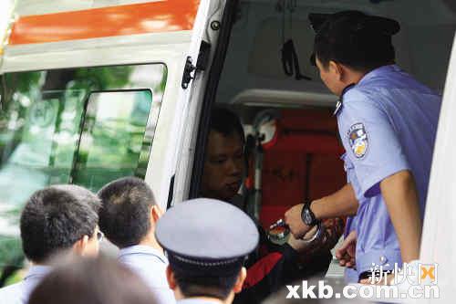警察在救护车上准备给男子戴手铐. 新快报记者 毕志毅/摄