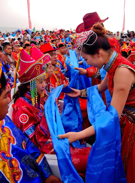 7月19日,蒙古族礼仪人员正在给新人献哈达